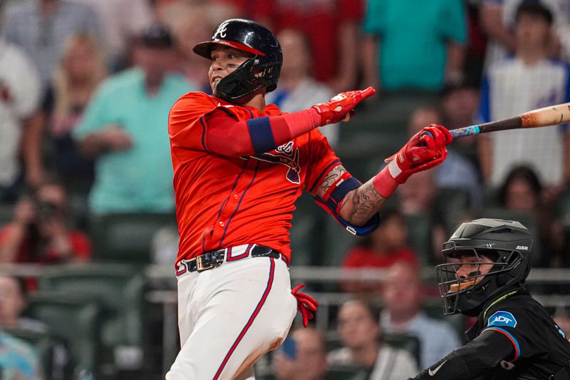 Aug 2, 2024; Cumberland, Georgia, USA; Atlanta Braves shortstop Orlando Arcia (11) hits a single to drive in a run against the Miami Marlins during the eighth inning at Truist Park. Mandatory Credit: Dale Zanine-USA TODAY Sports