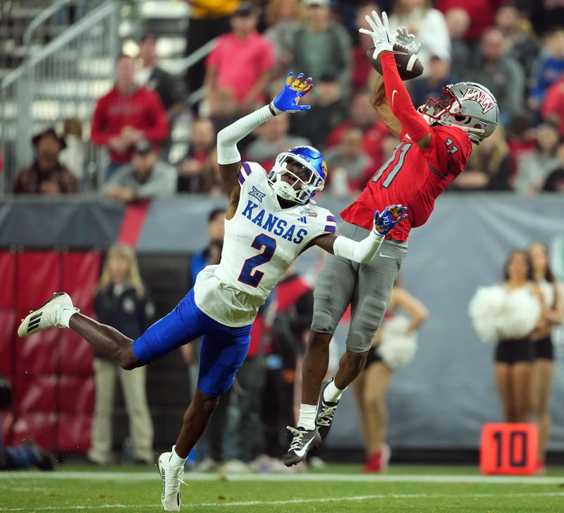 Dec 26, 2023; Phoenix, AZ, USA; UNLV Rebels wide receiver Ricky White (11) catches a touchdown pass against Kansas Jayhawks cornerback Cobee Bryant (2) during the second half at Chase Field. Mandatory Credit: Joe Camporeale-USA TODAY Sports