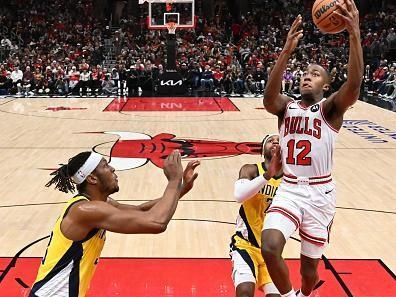 CHICAGO, ILLINOIS - DECEMBER 28:  Ayo Dosunmu #12 of the Chicago Bulls moves in for a lay up as Myles Turner #33 of the Indiana Pacers defends in the second half on December 28, 2023 at the United Center in Chicago, Illinois. Indiana defeated Chicago 120-104.   NOTE TO USER: User expressly acknowledges and agrees that, by downloading and or using this photograph, User is consenting to the terms and conditions of the Getty Images License Agreement.  (Photo by Jamie Sabau/Getty Images)