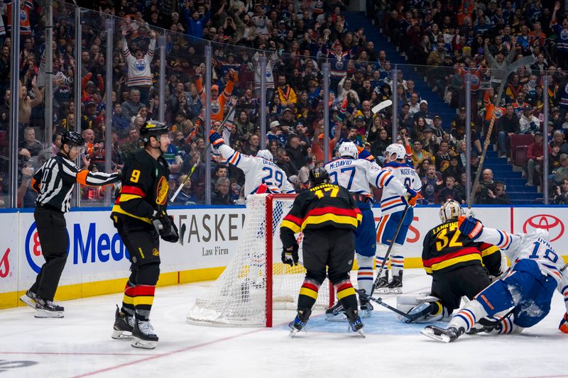 Nov 9, 2024; Vancouver, British Columbia, CAN; Vancouver Canucks forward J.T. Miller (9) and defenseman Filip Hronek (17) and goalie Kevin Lankinen (32) watch as Edmonton Oilers forward Leon Draisaitl (29) and forward Connor McDavid (97) and forward Ryan Nugent-Hopkins (93) celebrate Draisaitl’s goal during the first period at Rogers Arena. Mandatory Credit: Bob Frid-Imagn Images