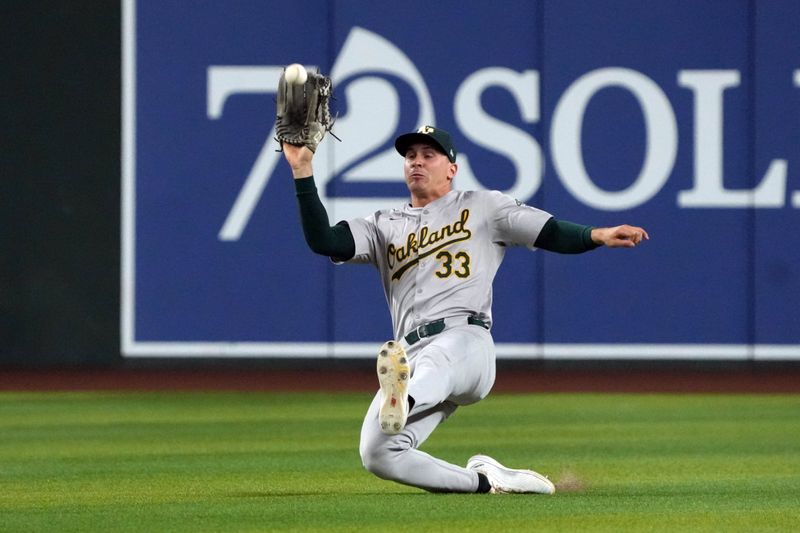 Jun 29, 2024; Phoenix, Arizona, USA; Oakland Athletics outfielder JJ Bleday (33) makes the slding catch against the Arizona Diamondbacks in the fourth inning at Chase Field. Mandatory Credit: Rick Scuteri-USA TODAY Sports