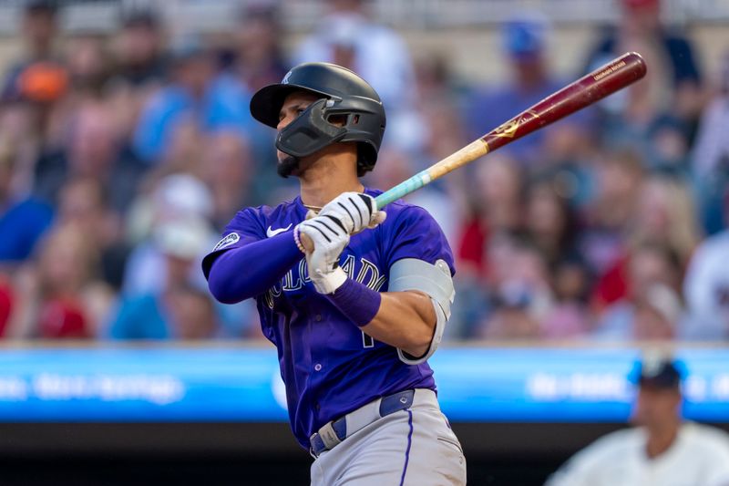 Jun 11, 2024; Minneapolis, Minnesota, USA; Colorado Rockies shortstop Ezequiel Tovar (14) hits a three run home run against the Minnesota Twins in the sixth inning at Target Field. Mandatory Credit: Jesse Johnson-USA TODAY Sports