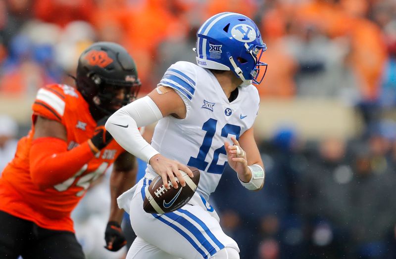 Nov 25, 2023; Stillwater, Oklahoma, USA;  BYU's Jake Retzlaff (12) scrambles during the first half against the Oklahoma State University Cowboys at Boone Pickens Stadium. Mandatory Credit: Sarah Phipps-USA TODAY Sports