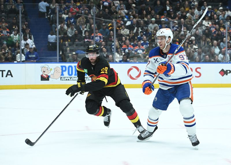 Oct 26, 2025; Vancouver, British Columbia, CAN; Edmonton Oilers center Connor McDavid (97) skates with Vancouver Canucks defenseman Marcus Pettersson (29) during the third period at Rogers Arena. Mandatory Credit: Simon Fearn-Imagn Images