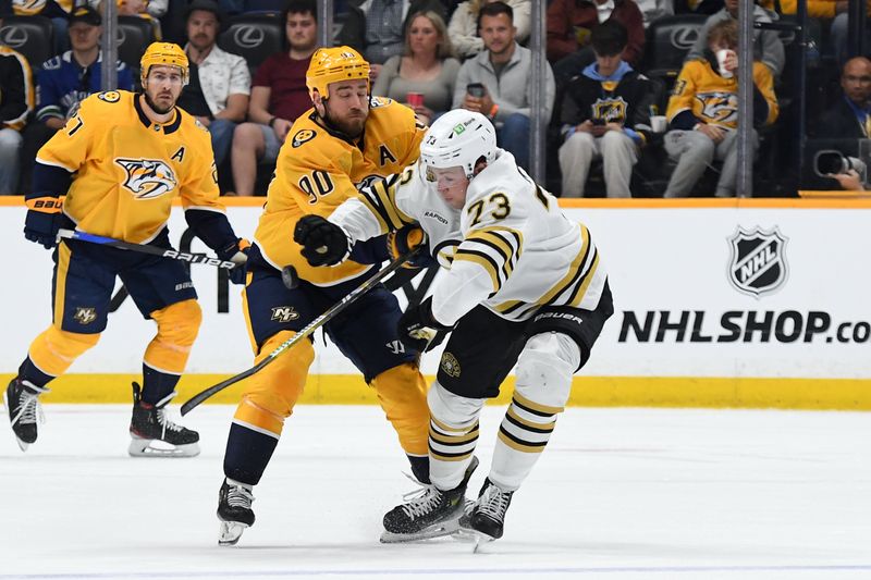 Apr 2, 2024; Nashville, Tennessee, USA; Nashville Predators center Ryan O'Reilly (90) tries to clear the puck against Boston Bruins defenseman Charlie McAvoy (73) during the first period at Bridgestone Arena. Mandatory Credit: Christopher Hanewinckel-USA TODAY Sports