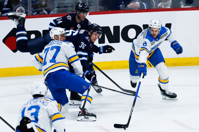Jan 20, 2026; Winnipeg, Manitoba, CAN; Winnipeg Jets forward Morgan Barron (36) and St. Louis Blues defenseman Philip Broberg (6) contest for the puck during the second period at Canada Life Centre. Mandatory Credit: Terrence Lee-Imagn Images