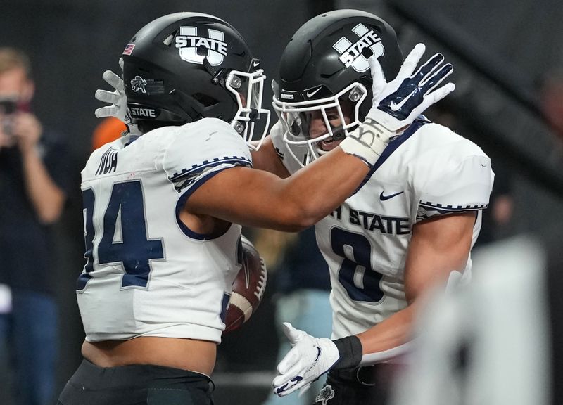 Oct 16, 2021; Paradise, Nevada, USA; Utah State Aggies running back Elelyon Noa (34) celebrates with Utah State Aggies wide receiver Derek Wright (8) after scoring the game-winning touchdown against the UNLV Rebels at Allegiant Stadium. Mandatory Credit: Stephen R. Sylvanie-USA TODAY Sports