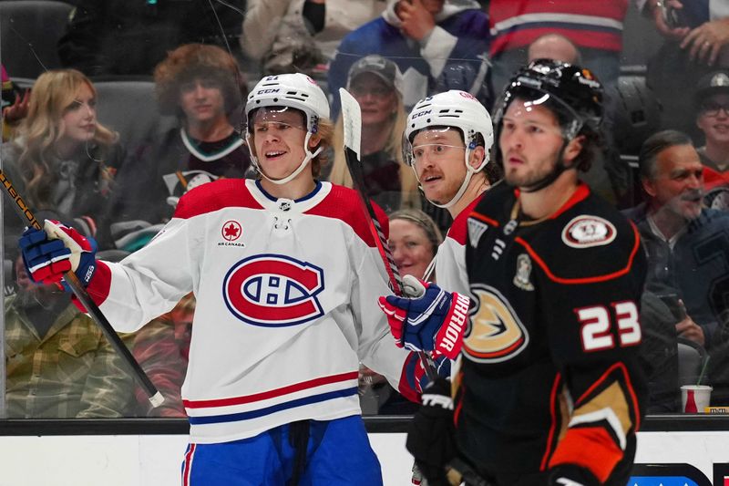 Nov 22, 2023; Anaheim, California, USA; Montreal Canadiens defenseman Kaiden Guhle (21) and left wing Michael Pezzetta (55) celebrate after a goal as Anaheim Ducks center Mason McTavish (23) reacts in the first period at Honda Center. Mandatory Credit: Kirby Lee-USA TODAY Sports