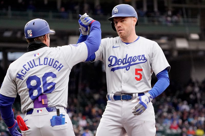 Apr 7, 2024; Chicago, Illinois, USA; Los Angeles Dodgers first baseman Freddie Freeman (5) celebrates with first base coach Clayton McCullough (86) after hitting a single against the Chicago Cubs during the first inning at Wrigley Field. Mandatory Credit: David Banks-USA TODAY Sports