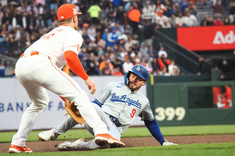 May 14, 2024; San Francisco, California, USA; Los Angeles Dodgers second baseman Gavin Lux (9) slides safely to third base against San Francisco Giants third baseman Matt Chapman (26) during the fourth inning at Oracle Park. Mandatory Credit: Kelley L Cox-USA TODAY Sports