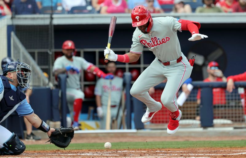 Feb 25, 2025; Port Charlotte, Florida, USA;  Philadelphia Phillies outfielder Johan Rojas (18) jumps over the pitch against the Tampa Bay Rays during the third inning at Charlotte Sports Park. Mandatory Credit: Kim Klement Neitzel-Imagn Images