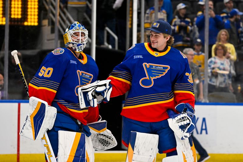 Mar 13, 2024; St. Louis, Missouri, USA;  St. Louis Blues goaltender Jordan Binnington (50) celebrates with goaltender Joel Hofer (30) after the Blues defeated the Los Angeles Kings at Enterprise Center. Mandatory Credit: Jeff Curry-USA TODAY Sports