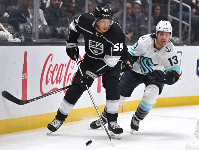 Oct 13, 2022; Los Angeles, California, USA; Los Angeles Kings center Quinton Byfield (55) skates the puck by Seattle Kraken left wing Brandon Tanev (13) in the first period at Crypto.com Arena. Mandatory Credit: Jayne Kamin-Oncea-USA TODAY Sports