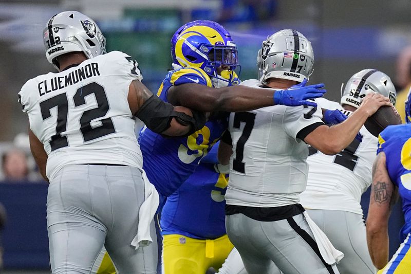 Las Vegas Raiders quarterback Brian Hoyer, right, is sacked by Los Angeles Rams linebacker Keir Thomas during the first half of a preseason NFL football game Saturday, Aug. 19, 2023, in Inglewood, Calif. (AP Photo/Mark J. Terrill)