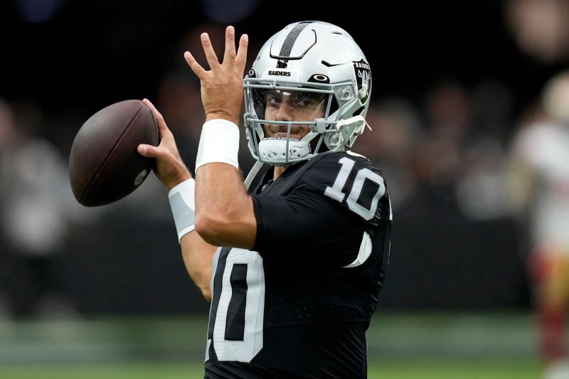 Las Vegas Raiders quarterback Jimmy Garoppolo (10) warms up prior to an NFL preseason football game against the San Francisco 49ers, Sunday, Aug. 13, 2023, in Las Vegas. (AP Photo/John Locher)