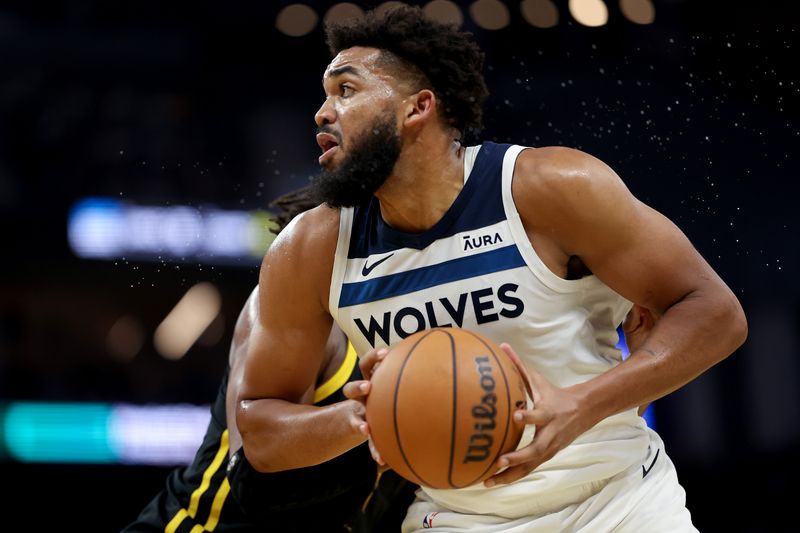 SAN FRANCISCO, CALIFORNIA - NOVEMBER 14: Karl-Anthony Towns #32 of the Minnesota Timberwolves is guarded by Kevon Looney #5 of the Golden State Warriors at Chase Center on November 14, 2023 in San Francisco, California. NOTE TO USER: User expressly acknowledges and agrees that, by downloading and or using this photograph, User is consenting to the terms and conditions of the Getty Images License Agreement.  (Photo by Ezra Shaw/Getty Images)