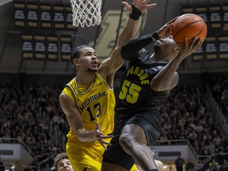 Jan 23, 2024; West Lafayette, Indiana, USA; Michigan Wolverines forward Olivier Nkamhoua (13) jumps to block a shot by Purdue Boilermakers guard Lance Jones (55) during the second half at Mackey Arena. Mandatory Credit: Marc Lebryk-USA TODAY Sports