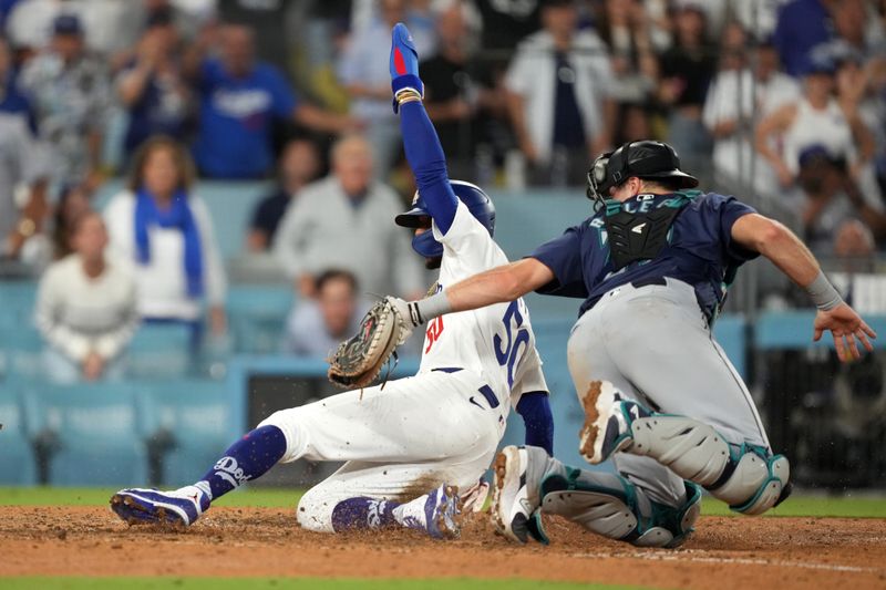 Aug 20, 2024; Los Angeles, California, USA; Los Angeles Dodgers right fielder Mookie Betts (50) is tagged out at home plate by Seattle Mariners catcher Cal Raleigh (29) in the seventh inning at Dodger Stadium. Mandatory Credit: Kirby Lee-USA TODAY Sports