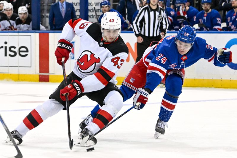 Dec 2, 2024; New York, New York, USA;  New Jersey Devils defenseman Luke Hughes (43) skates in between New York Rangers right wing Kaapo Kakko (24) and left wing Will Cuylle (50) during the first period at Madison Square Garden. Mandatory Credit: Dennis Schneidler-Imagn Images