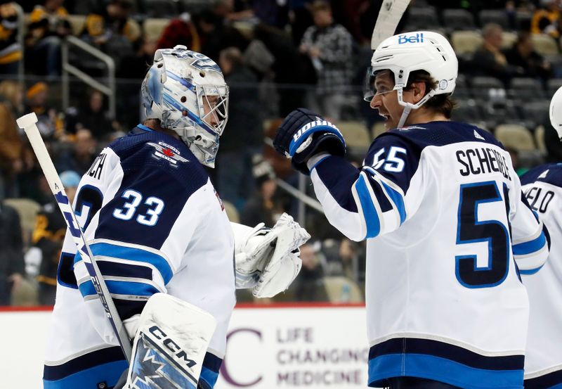 Jan 13, 2023; Pittsburgh, Pennsylvania, USA;  Winnipeg Jets goaltender David Rittich (33) and center Mark Scheifele (55) celebrate after defeating the Pittsburgh Penguins at PPG Paints Arena. The Jets won 4-1. Mandatory Credit: Charles LeClaire-USA TODAY Sports