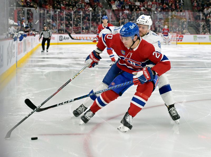 Nov 7, 2023; Montreal, Quebec, CAN; Montreal Canadiens forward Juraj Slafkovsky (20) plays the puck and Tampa Bay Lightning defenseman Erik Cernak (81) defends during the third period at the Bell Centre. Mandatory Credit: Eric Bolte-USA TODAY Sports