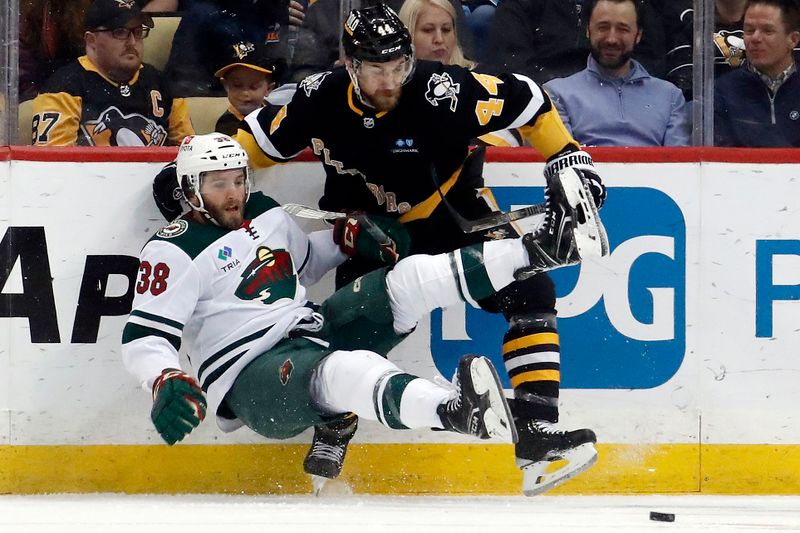 Apr 6, 2023; Pittsburgh, Pennsylvania, USA; Pittsburgh Penguins defenseman Jan Rutta (44) checks Minnesota Wild right wing Ryan Hartman (38) during the second period at PPG Paints Arena. Pittsburgh won 4-1.Mandatory Credit: Charles LeClaire-USA TODAY Sports