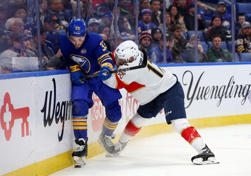 Feb 15, 2024; Buffalo, New York, USA;  Florida Panthers left wing Jonah Gadjovich (12) checks Buffalo Sabres defenseman Ryan Johnson (33) as he goes after a loose puck during the first period at KeyBank Center. Mandatory Credit: Timothy T. Ludwig-USA TODAY Sports