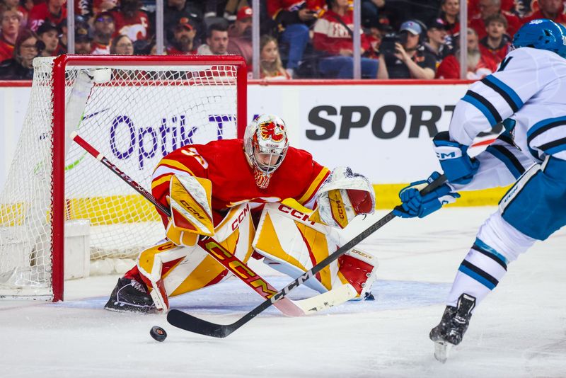 Apr 18, 2024; Calgary, Alberta, CAN; Calgary Flames goaltender Dustin Wolf (32) makes a save against San Jose Sharks center Luke Kunin (11) during the third period at Scotiabank Saddledome. Mandatory Credit: Sergei Belski-USA TODAY Sports