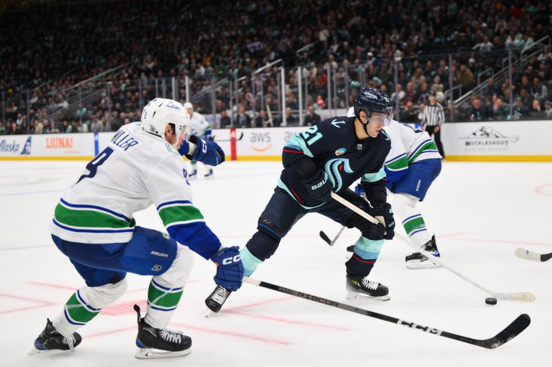 Feb 22, 2024; Seattle, Washington, USA; Seattle Kraken center Alex Wennberg (21) plays the puck while defended by Vancouver Canucks center J.T. Miller (9) during the third period at Climate Pledge Arena. Mandatory Credit: Steven Bisig-USA TODAY Sports