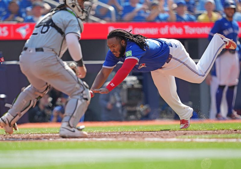 May 20, 2024; Toronto, Ontario, CAN; Toronto Blue Jays first base Vladimir Guerrero Jr. (27) slides into home plate scoring a run against the Chicago White Sox during the sixth inning at Rogers Centre. Mandatory Credit: Nick Turchiaro-USA TODAY Sports