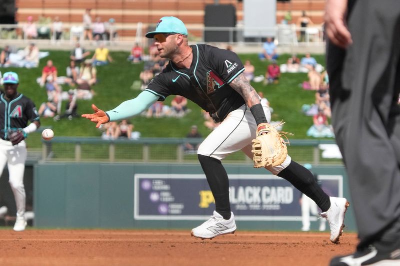 Feb 27, 2024; Salt River Pima-Maricopa, Arizona, USA; Arizona Diamondbacks first baseman Christian Walker (53) flips the ball for an out against the Texas Rangers during the second inning at Salt River Fields at Talking Stick. Mandatory Credit: Rick Scuteri-USA TODAY Sports