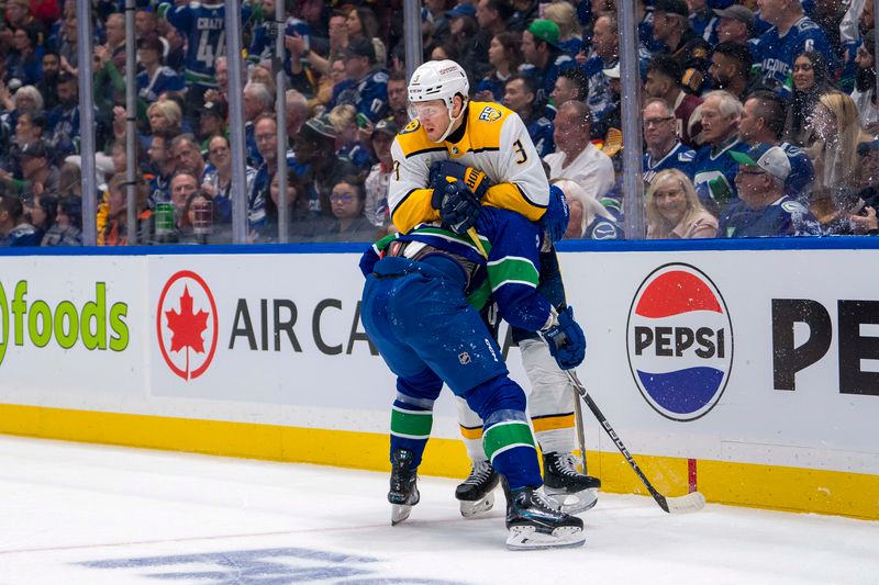 Apr 21, 2024; Vancouver, British Columbia, CAN; Vancouver Canucks forward Phillip Di Giuseppe (34) checks Nashville Predators defenseman Jeremy Lauzon (3) in the first period in game one of the first round of the 2024 Stanley Cup Playoffs at Rogers Arena. Mandatory Credit: Bob Frid-USA TODAY Sports