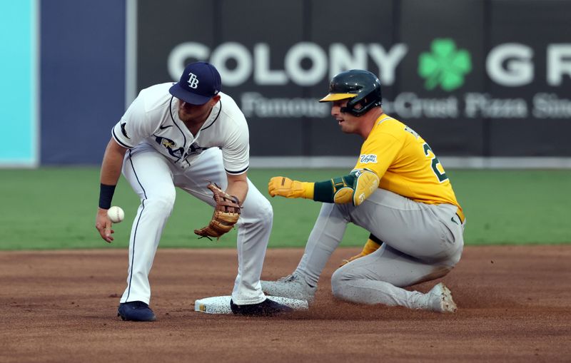 Jun 30, 2025; Tampa, Florida, USA; Athletics designated hitter Brent Rooker (25) slides safe into second base as he doubles and Tampa Bay Rays infielder Curtis Mead (25) attempts to tag him out at George M. Steinbrenner Field. Mandatory Credit: Kim Klement Neitzel-Imagn Images