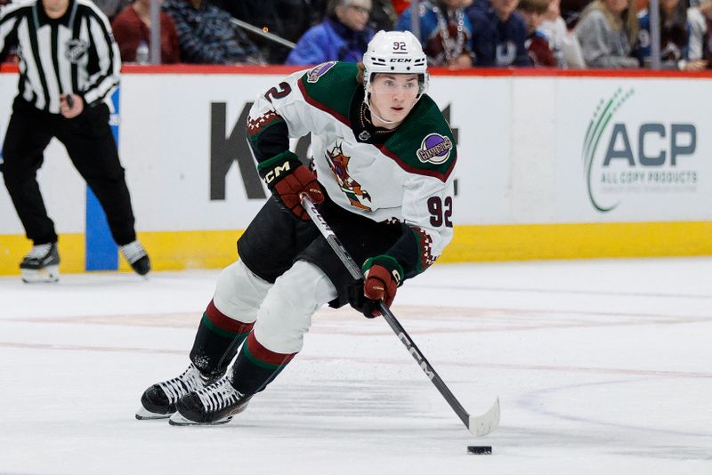 Dec 23, 2023; Denver, Colorado, USA; Arizona Coyotes center Logan Cooley (92) controls the puck in the first period against the Colorado Avalanche at Ball Arena. Mandatory Credit: Isaiah J. Downing-USA TODAY Sports