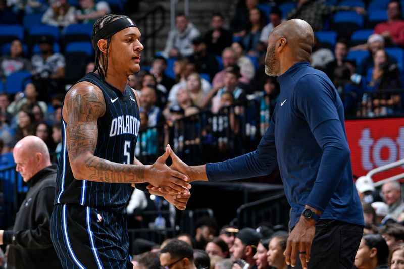 ORLANDO, FL - MARCH 19: Paolo Banchero #5 and Head Coach Jamahl Mosley of the Orlando Magic high five during the game against the Charlotte Hornets on March 19, 2024 at the Kia Center in Orlando, Florida. NOTE TO USER: User expressly acknowledges and agrees that, by downloading and or using this photograph, User is consenting to the terms and conditions of the Getty Images License Agreement. Mandatory Copyright Notice: Copyright 2024 NBAE (Photo by Fernando Medina/NBAE via Getty Images)