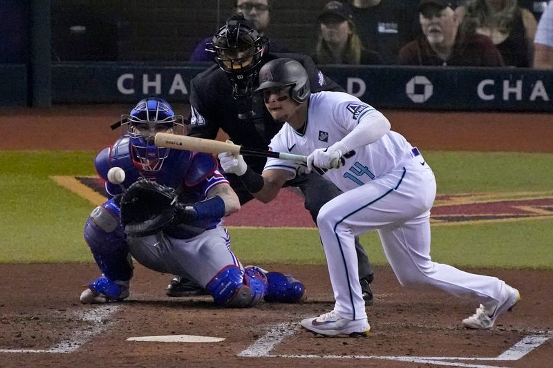 Nov 1, 2023; Phoenix, Arizona, USA; Arizona Diamondbacks catcher Gabriel Moreno (14) lays down a bunt against the Texas Rangers during the third inning in game five of the 2023 World Series at Chase Field. Mandatory Credit: Rick Scuteri-USA TODAY Sports