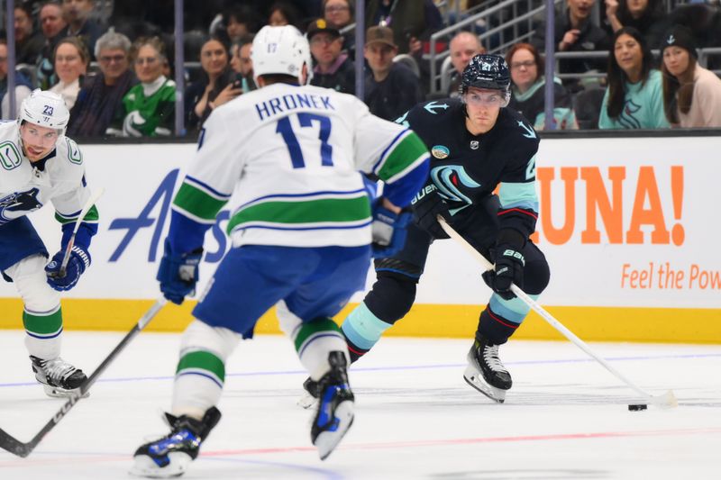 Feb 22, 2024; Seattle, Washington, USA; Seattle Kraken center Alex Wennberg (21) plays the puck against the Vancouver Canucks during the second period at Climate Pledge Arena. Mandatory Credit: Steven Bisig-USA TODAY Sports