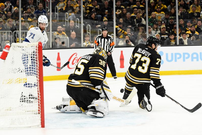 Feb 13, 2024; Boston, Massachusetts, USA; Boston Bruins goaltender Linus Ullmark (35) makes a save in front of defenseman Charlie McAvoy (73) while Tampa Bay Lightning center Anthony Cirelli (71) looks on during the second period at TD Garden. Mandatory Credit: Bob DeChiara-USA TODAY Sports