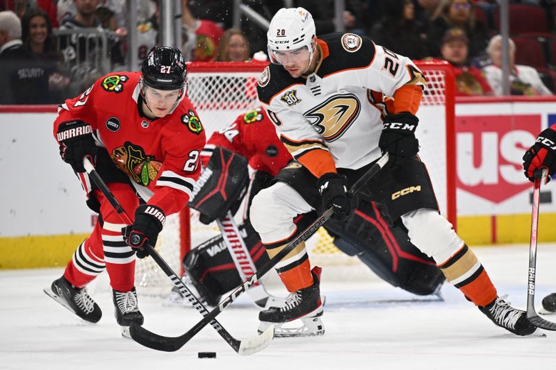 Dec 7, 2023; Chicago, Illinois, USA; Chicago Blackhawks forward Lukas Reichel (27) and Anaheim Ducks forward Brett Leason (20) battle for control of the puck in the second period at United Center. Mandatory Credit: Jamie Sabau-USA TODAY Sports