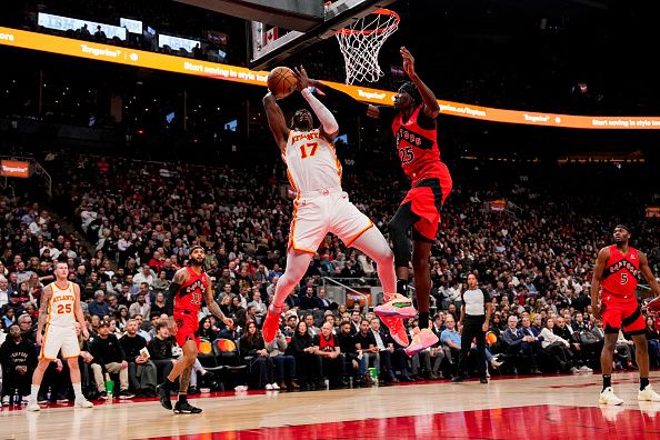 TORONTO, ON - DECEMBER 13: Onyeka Okongwu #17 of the Atlanta Hawks goes to the basket against Chris Boucher #25 of the Toronto Raptors during first half NBA action at Scotiabank Arena on December 13, 2023 in Toronto, Ontario, Canada. NOTE TO USER: User expressly acknowledges and agrees that, by downloading and/or using this Photograph, user is consenting to the terms and conditions of the Getty Images License Agreement. (Photo by Andrew Lahodynskyj/Getty Images)