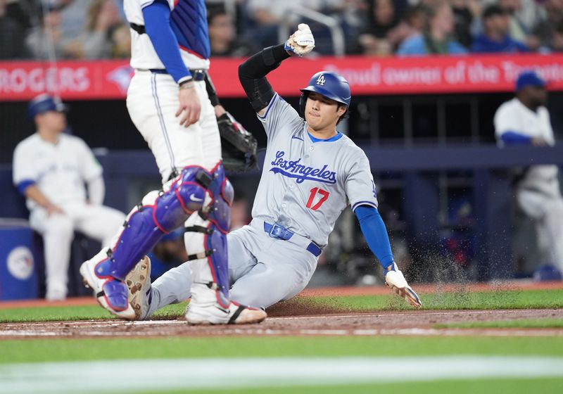 Apr 26, 2024; Toronto, Ontario, CAN; Los Angeles Dodgers designated hitter Shohei Ohtani (17) slides into home and scores a run against the Toronto Blue Jays during the third inning at Rogers Centre. Mandatory Credit: Nick Turchiaro-USA TODAY Sports