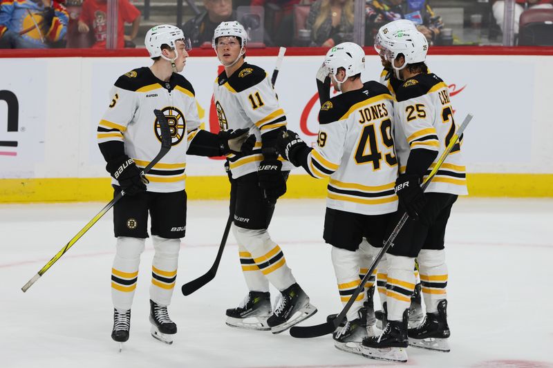 Oct 8, 2024; Sunrise, Florida, USA; Boston Bruins center Trent Frederic (11) celebrates with teammates after scoring against the Florida Panthers during the third period at Amerant Bank Arena. Mandatory Credit: Sam Navarro-Imagn Images