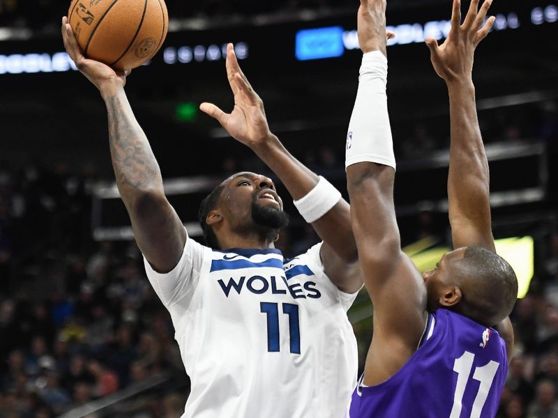 SALT LAKE CITY, UTAH - MARCH 18: Naz Reid #11 of the Minnesota Timberwolves shoots over Kris Dunn #11 of the Utah Jazz during the first half of a game at Delta Center on March 18, 2024 in Salt Lake City, Utah. NOTE TO USER: User expressly acknowledges and agrees that, by downloading and or using this photograph, User is consenting to the terms and conditions of the Getty Images License Agreement.  (Photo by Alex Goodlett/Getty Images)