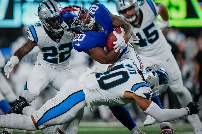 Carolina Panthers linebacker Brandon Smith and safety Jammie Robinson tackle New York Giants running back Eric Gray an NFL preseason football game, Friday, Aug. 18, 2023, in East Rutherford, N.J. (AP Photo/Bryan Woolston)