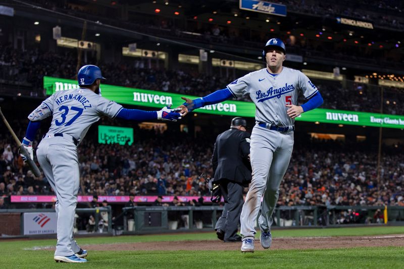 May 15, 2024; San Francisco, California, USA; Los Angeles Dodgers first baseman Freddie Freeman (5) is congratulated by left fielder Teoscar Hernandez (37) after he scored against the San Francisco Giants during the eighth inning at Oracle Park. Mandatory Credit: John Hefti-USA TODAY Sports