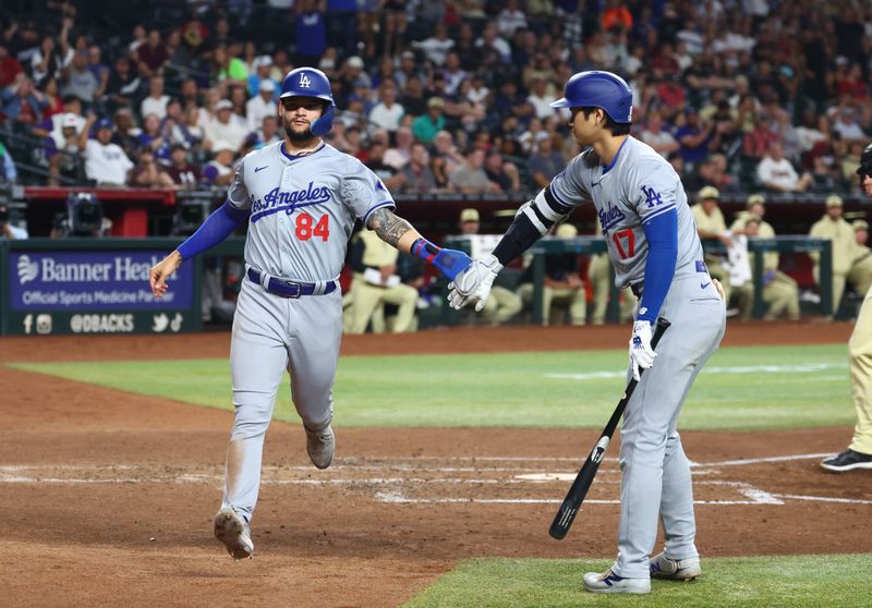 Apr 30, 2024; Phoenix, Arizona, USA; Los Angeles Dodgers base runner Andy Pages (left) celebrates with Shohei Ohtani after scoring on a wild pitch in the fifth inning against the Arizona Diamondbacks at Chase Field. Mandatory Credit: Mark J. Rebilas-USA TODAY Sports