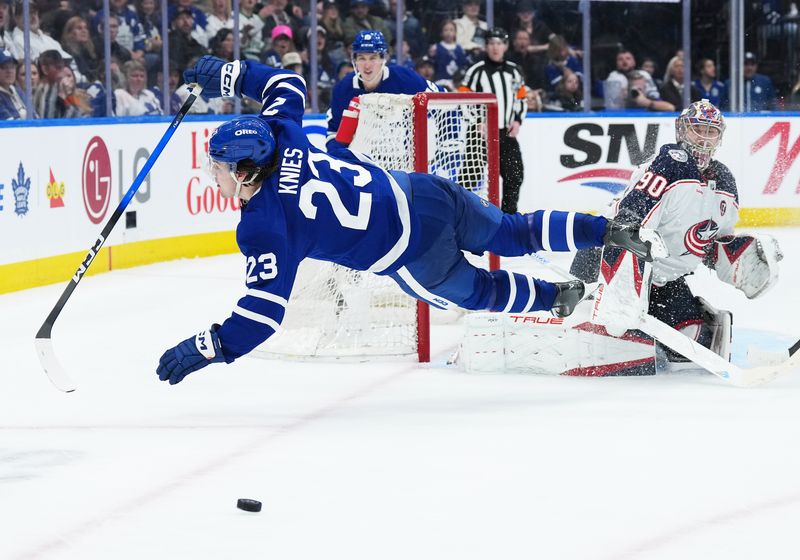 Apr 5, 2025; Toronto, Ontario, CAN; Toronto Maple Leafs left wing Matthew Knies (23) battles for the puck with Columbus Blue Jackets goaltender Elvis Merzlikins (90) during the third period at Scotiabank Arena. Mandatory Credit: Nick Turchiaro-Imagn Images