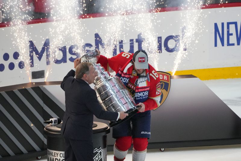 Jun 24, 2024; Sunrise, Florida, USA; The Stanley Cup is presented to Florida Panthers forward Aleksander Barkov (16) by NHL Commissioner Gary Bettman after winning against the Edmonton Oilers in game seven of the 2024 Stanley Cup Final at Amerant Bank Arena. Mandatory Credit: Jim Rassol-USA TODAY Sports