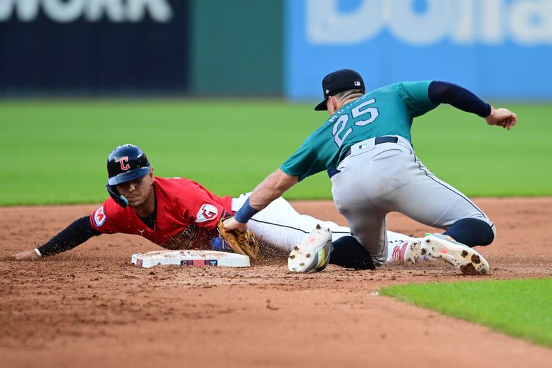 Jun 19, 2024; Cleveland, Ohio, USA; Cleveland Guardians second baseman Andres Gimenez (0) steals second as Seattle Mariners shortstop Dylan Moore (25) is late with the tag during the fifth inning at Progressive Field. Mandatory Credit: Ken Blaze-USA TODAY Sports