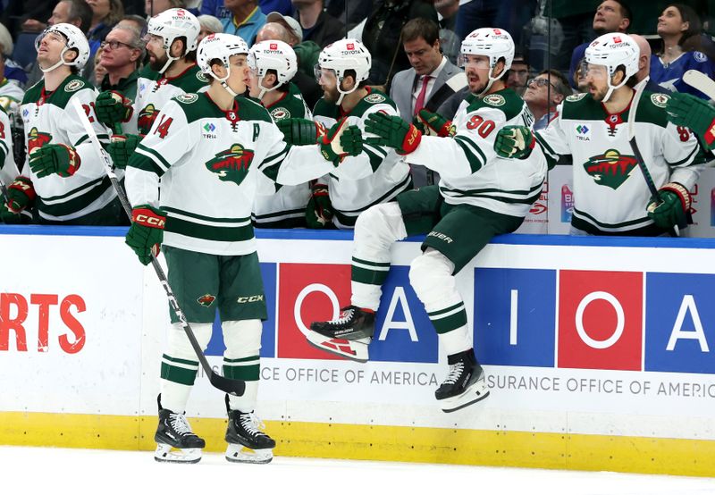 Jan 18, 2024; Tampa, Florida, USA; Minnesota Wild center Joel Eriksson Ek (14) is congratulated after scoring against the Tampa Bay Lightning during the first period at Amalie Arena. Mandatory Credit: Kim Klement Neitzel-USA TODAY Sports